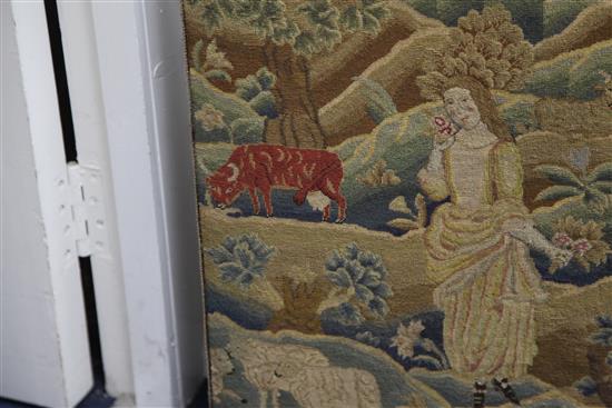 An 18th century needlework panel depicting a shepherdess in a landscape, 26.5 x 22in.